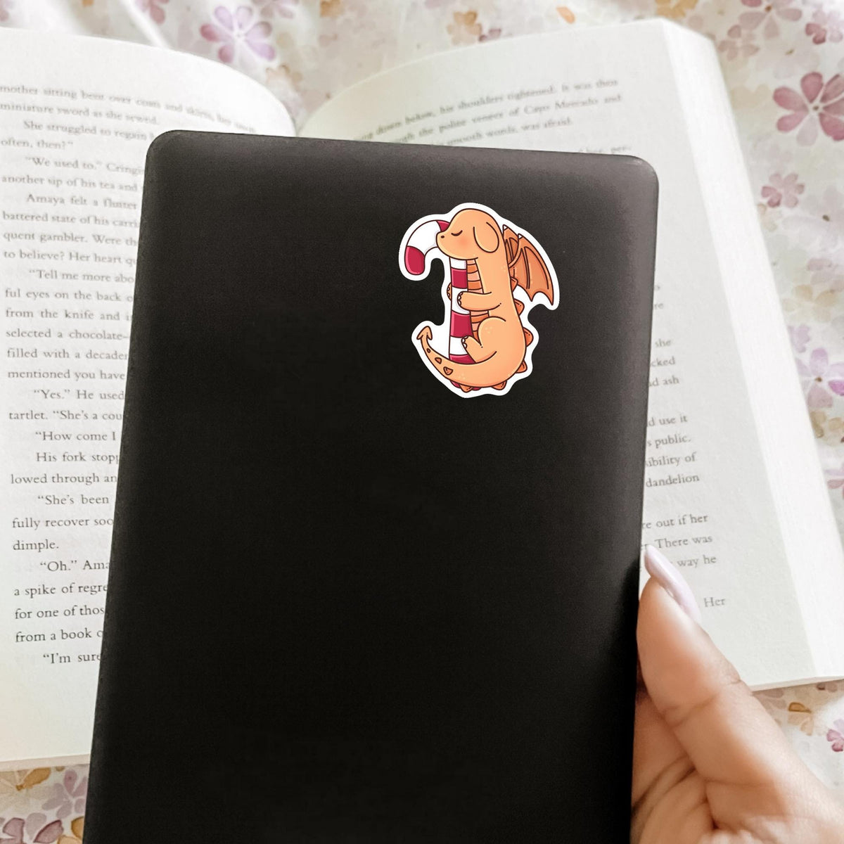 Candy Cane Dragon waterproof sticker on the back of a black e-reader or Kindle, cute holiday fantasy decal for e-readers, phone cases and tablets
