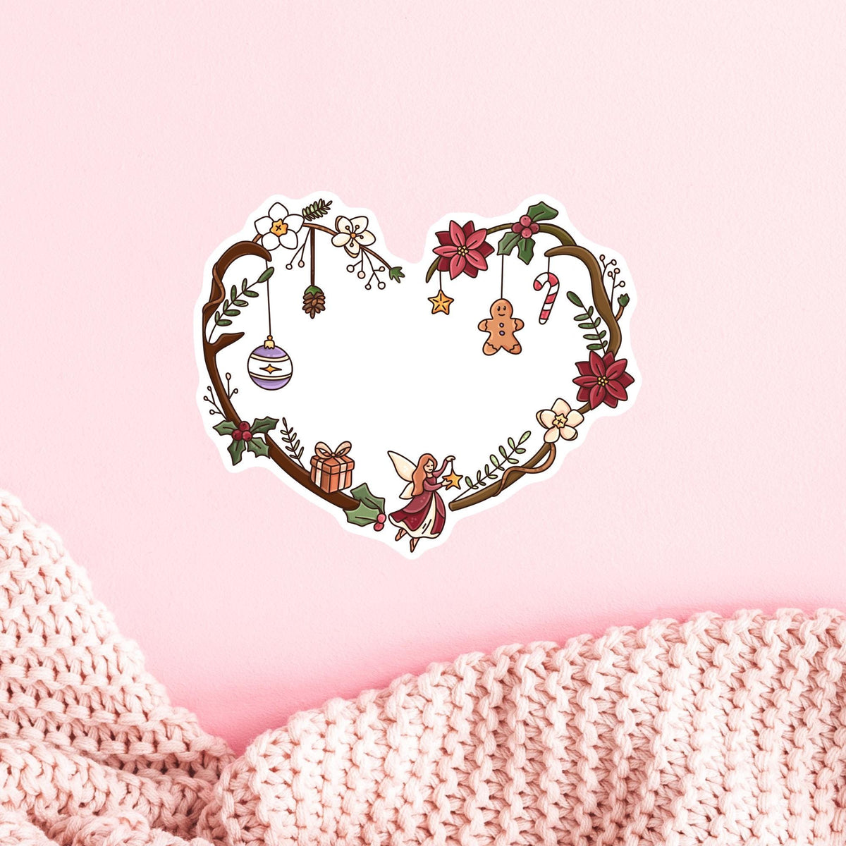 Christmas Fairy Heart die-cut sticker on pink background, whimsical holiday heart wreath decal in matte, glitter and holographic finish