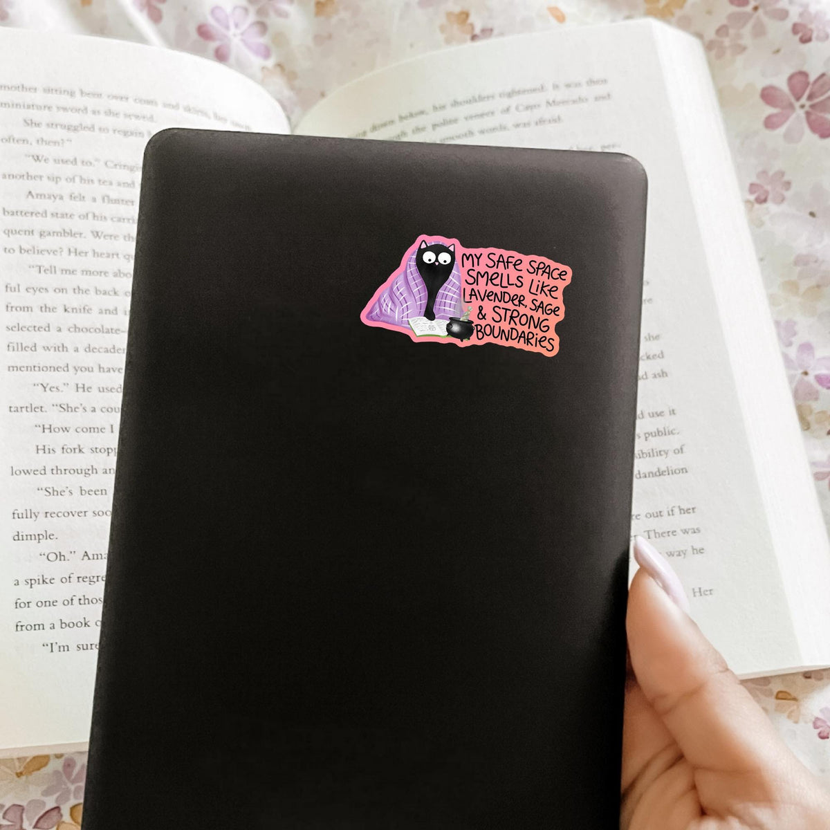 Black cat lavender blanket sticker on a black notebook