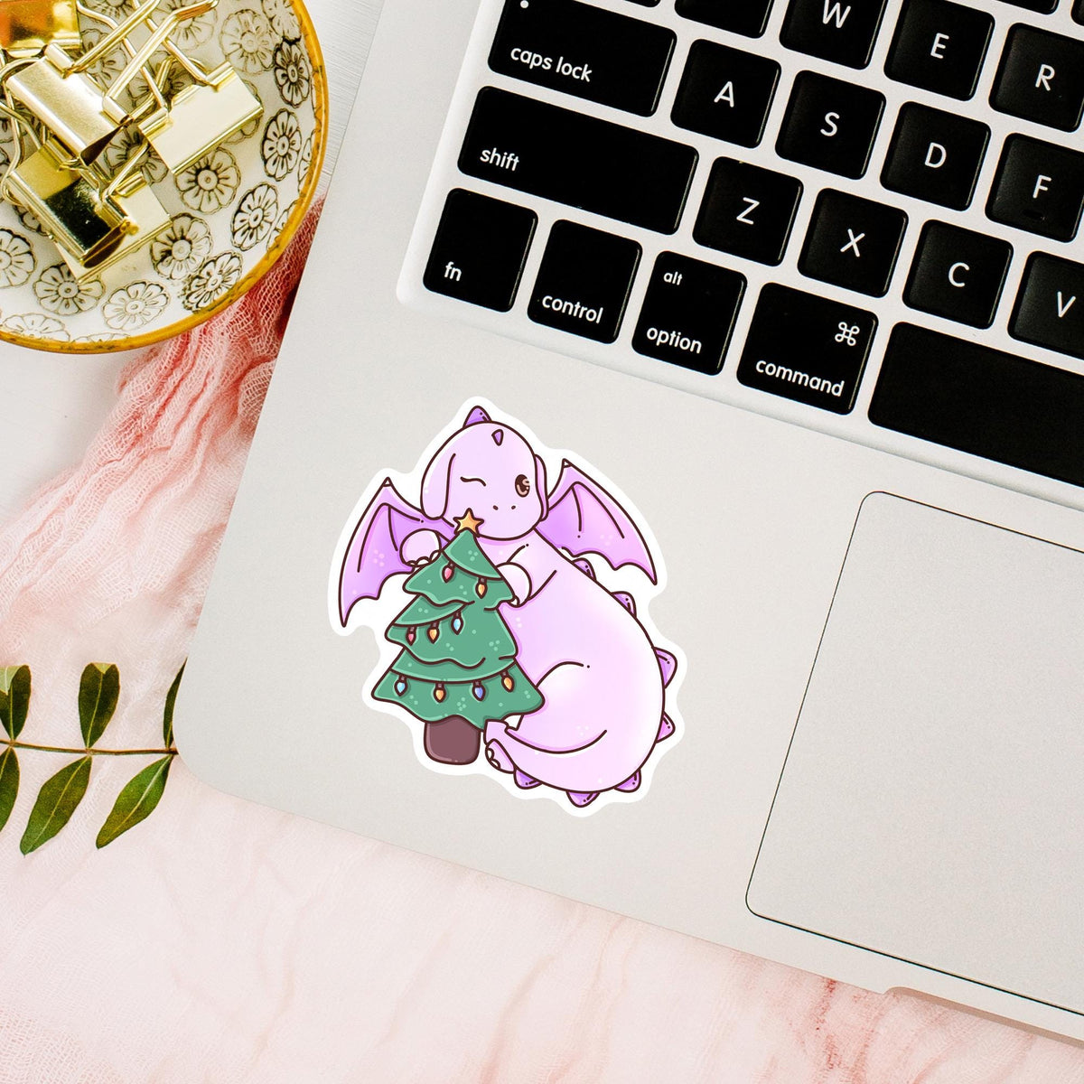 Waterproof Christmas Tree Dragon sticker on a laptop beside the keyboard, cute fantasy vinyl decal for laptops, planners and holiday decorating