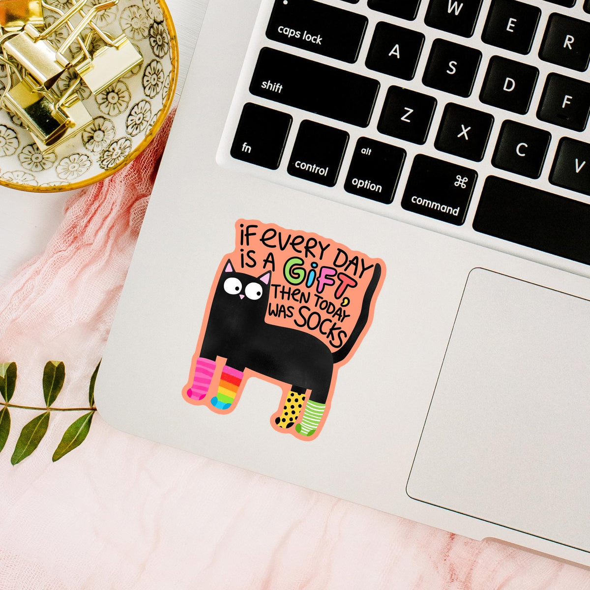 Black cat socks sticker on a laptop keyboard with gold decor