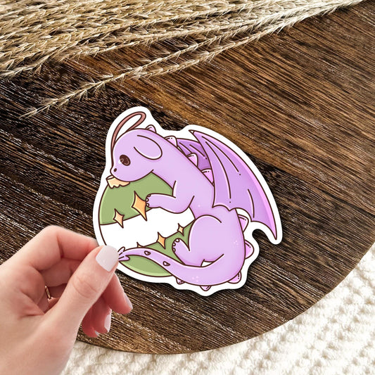 Ornament Dragon waterproof vinyl sticker held in hand over a wood table, cute Christmas fantasy dragon decal gift for dragon and holiday lovers