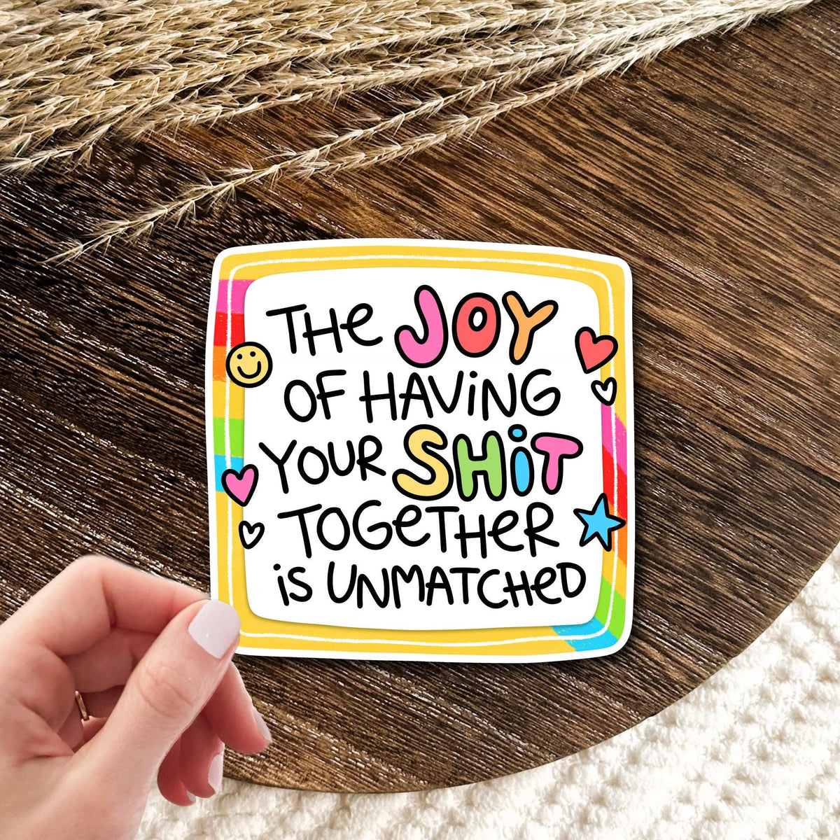 Joy Of Having Your Life Together rainbow frame vinyl die-cut sticker held in hand on wood, funny adulting humor gift