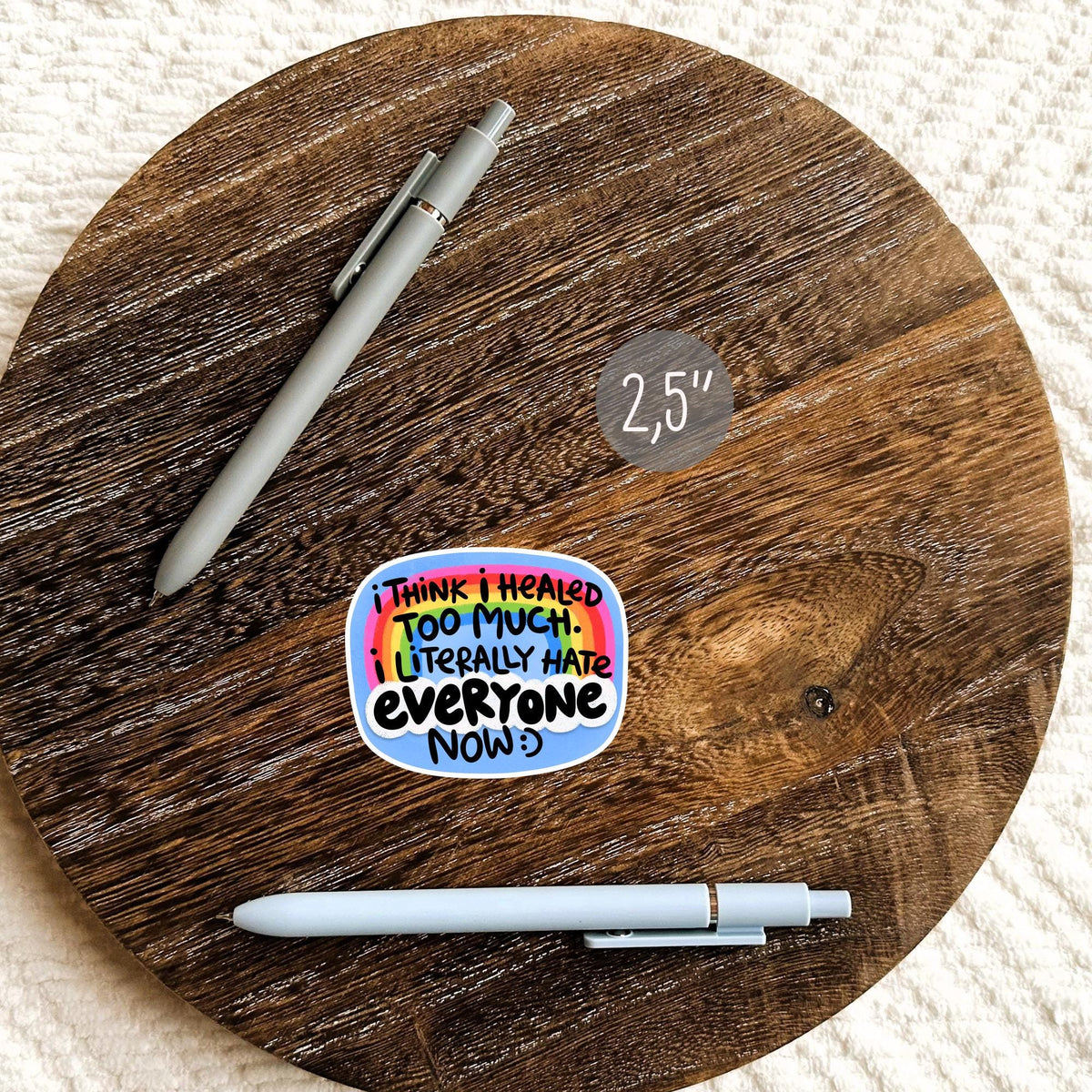Funny Healed Too Much sticker beside a pen on a round wooden surface, waterproof sarcastic quote decal gift for notebook and planner fans