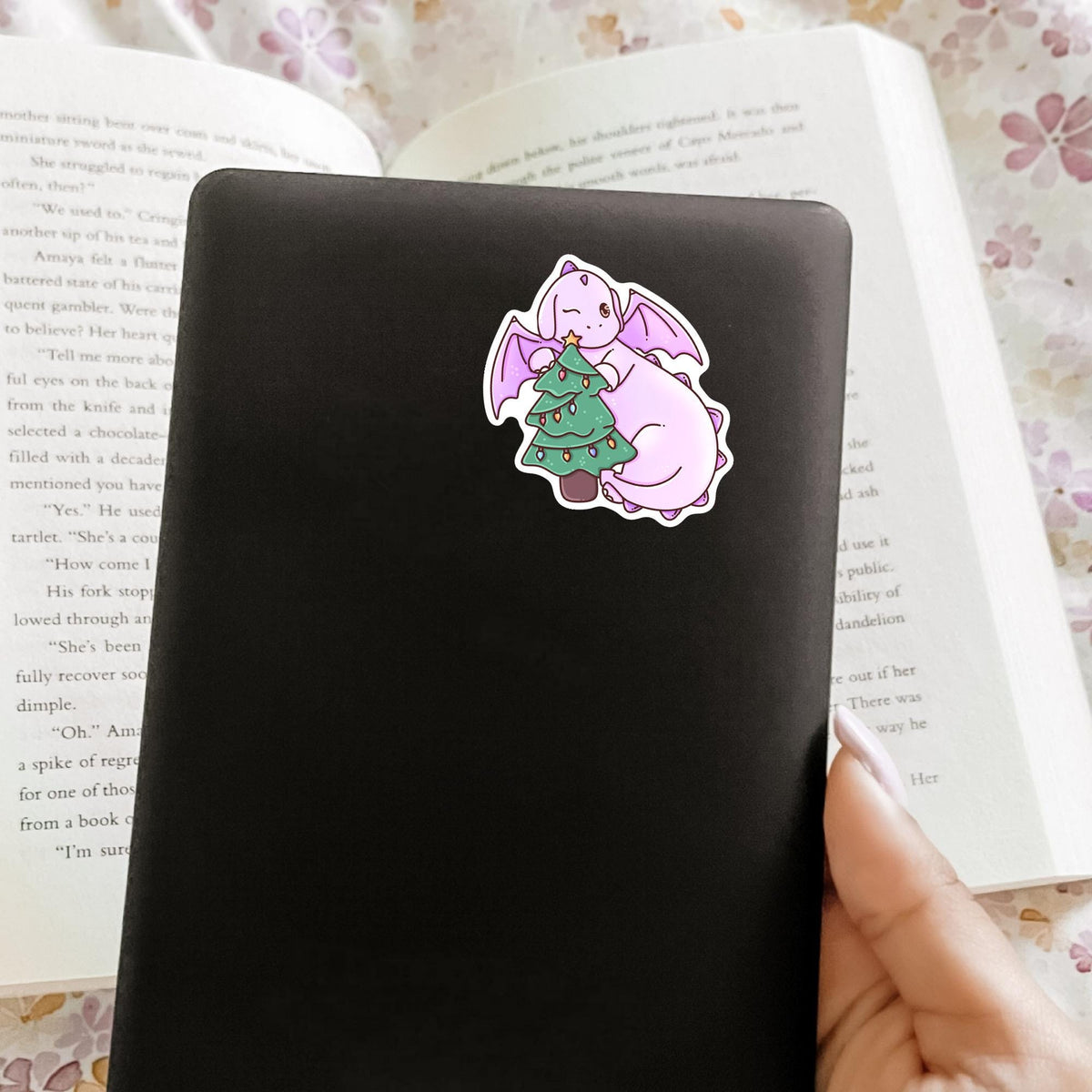 Christmas Tree Dragon vinyl sticker on a gray laptop lid held by hand, waterproof festive decal for laptop and tablet decoration