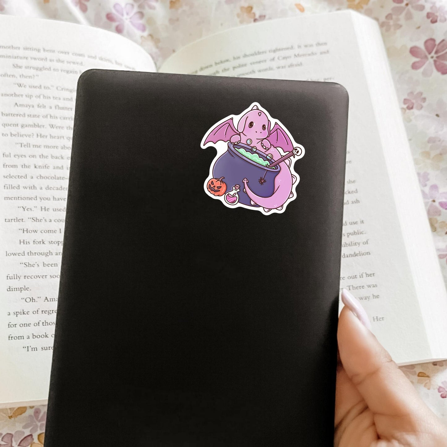 Halloween Pink Dragon sticker on a notebook, spooky pastel aesthetic vinyl sticker for fantasy readers and witch lovers