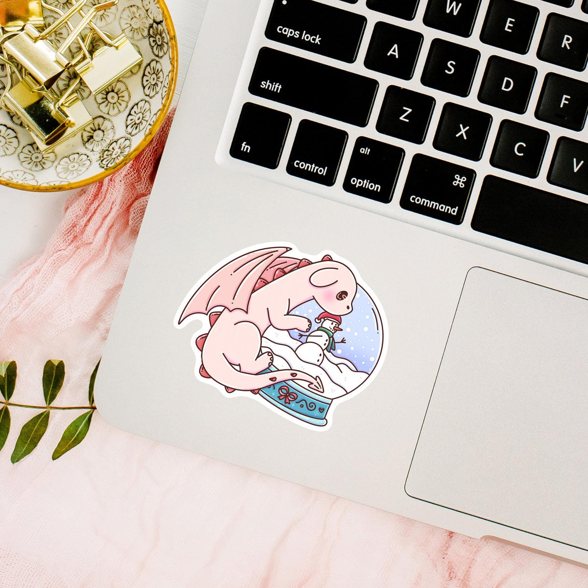 Waterproof Snow Globe Dragon sticker on a laptop beside a keyboard, cute vinyl decal for fantasy lovers and winter aesthetic fans