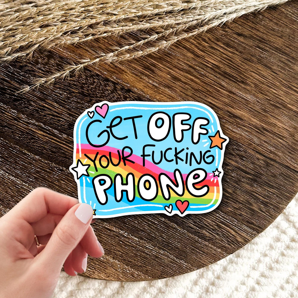 Get Off Your Phone rainbow vinyl die-cut sticker held in hand on wood, funny sarcastic screen time humor gift