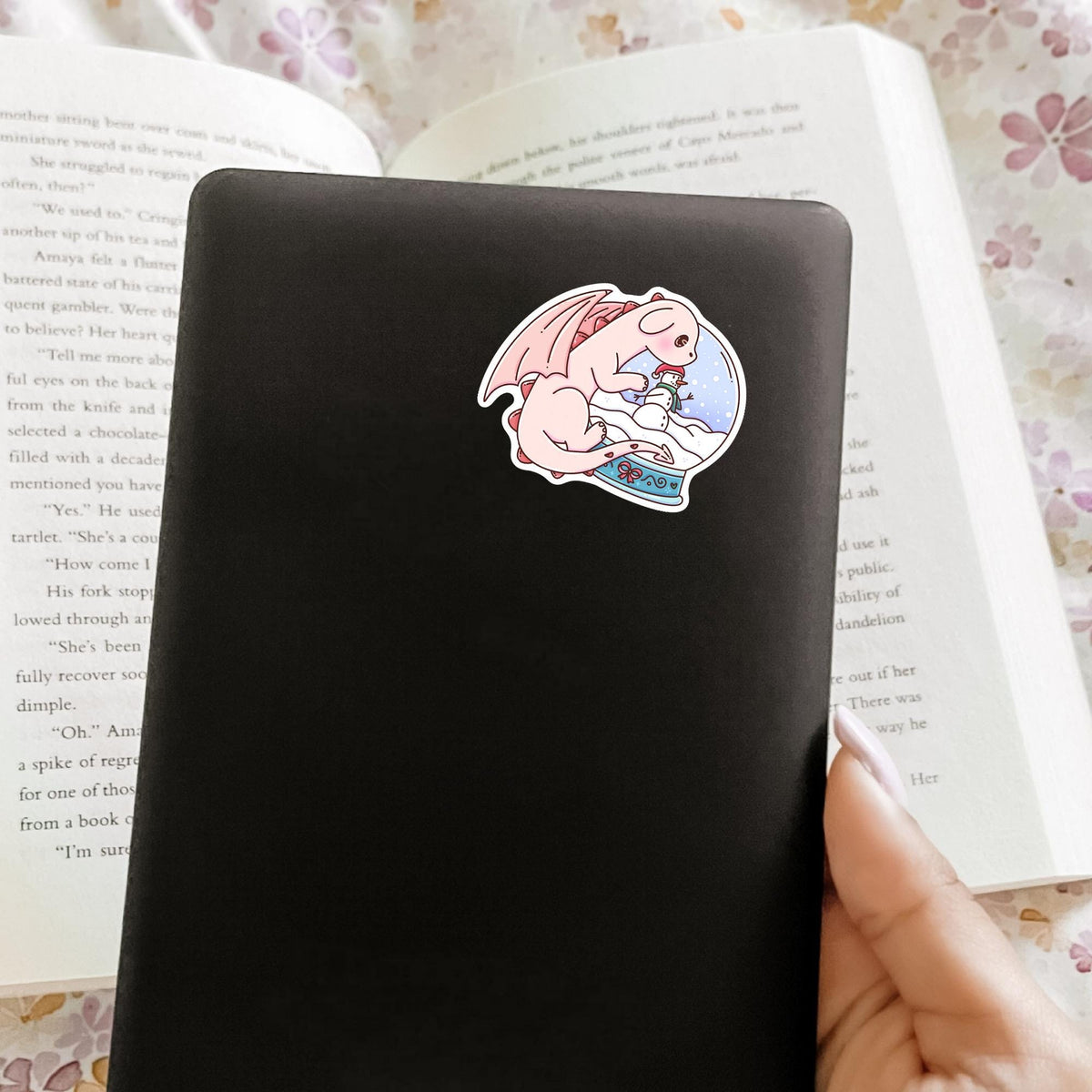 Snow Globe Dragon vinyl sticker on a gray notebook cover, cute journal decal and stationery gift for fantasy and dragon lovers
