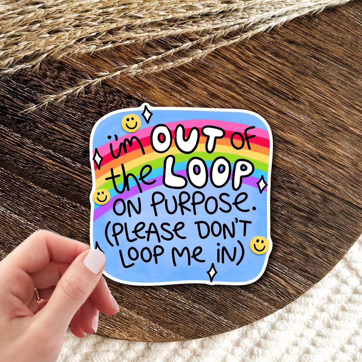 I'm Out Of The Loop On Purpose rainbow vinyl die-cut sticker held in hand on wood, funny introvert humor gift