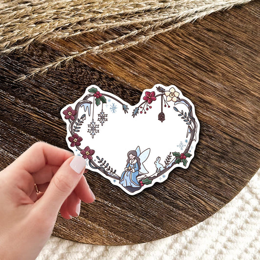 Winter Fairy Heart vinyl die-cut sticker held in hand, cute waterproof fairy and bunny sticker with winter florals, gift for fantasy and cottagecore lovers